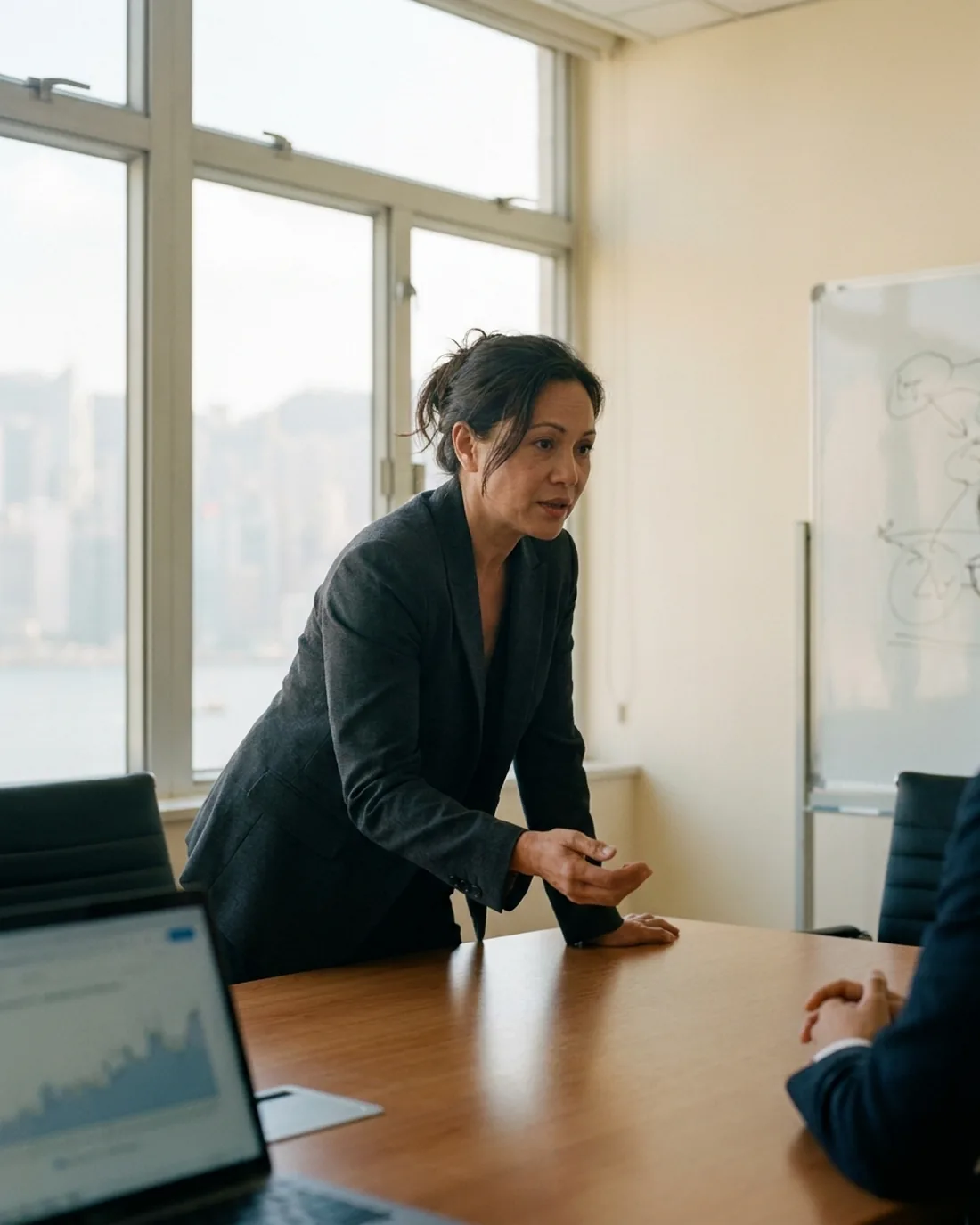 A senior CRO reviewing the work in a calm Hong Kong boardroom